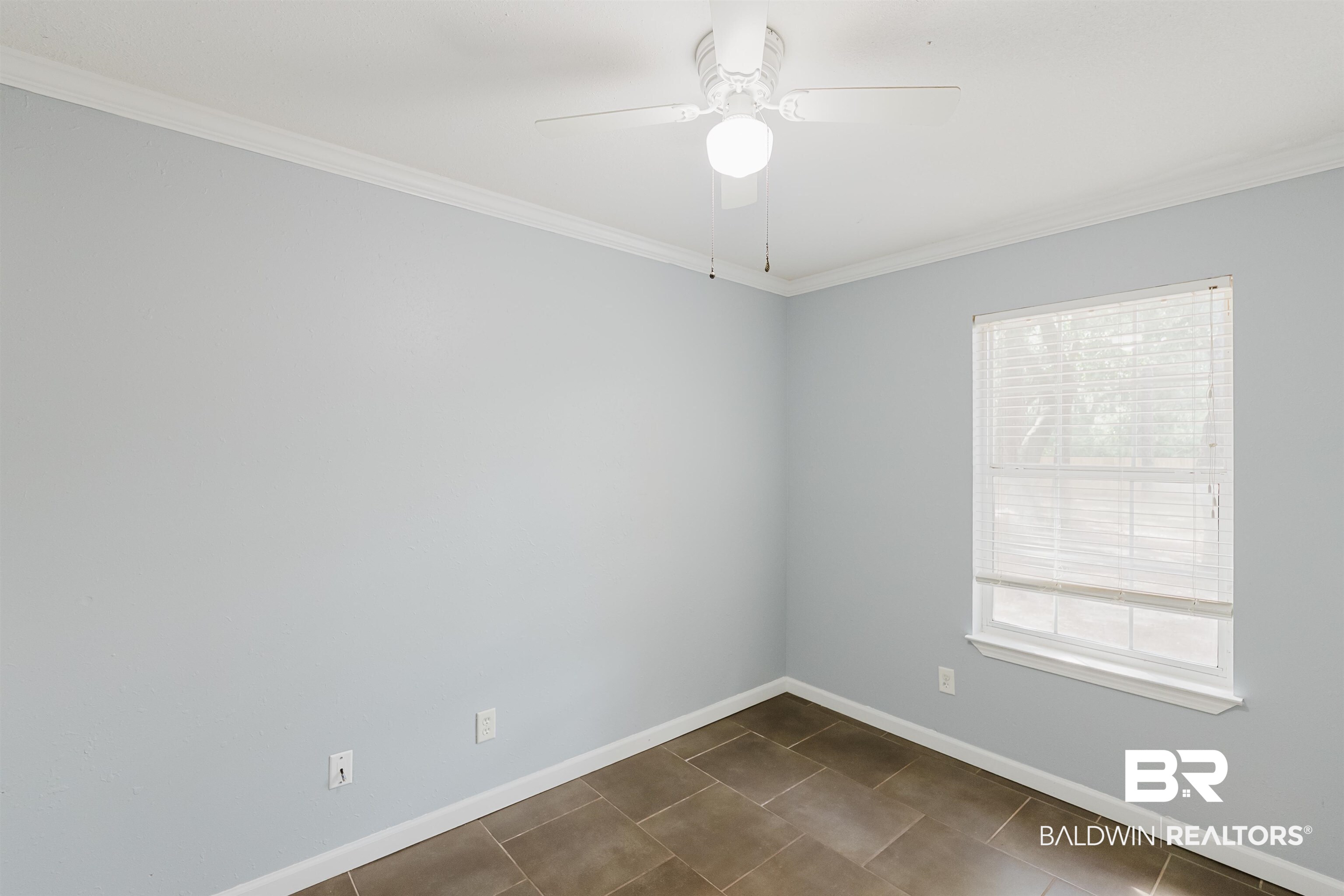 14185 Jackson Lane Foley, AL 36535 - Photo 11 of 16 Spare room with crown molding, a ceiling fan, and dark tile patterned flooring
