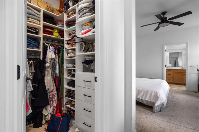 a view of walk in closet with clothes and shoes