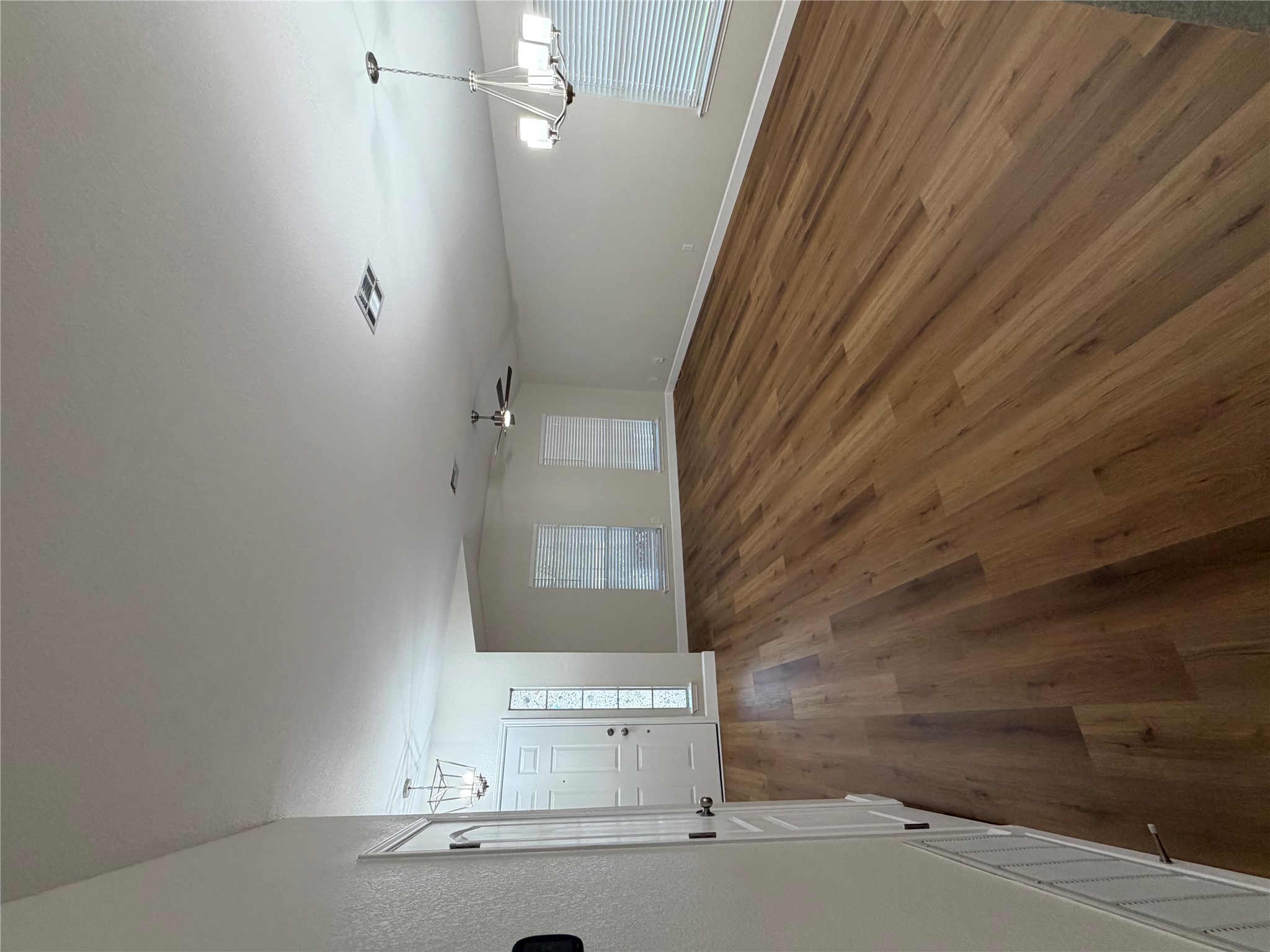 4604 Ramies Run Austin, TX 78749 - Photo 9 of 38 Rich wood-look flooring stretches across a spacious living area featuring high vaulted ceilings.