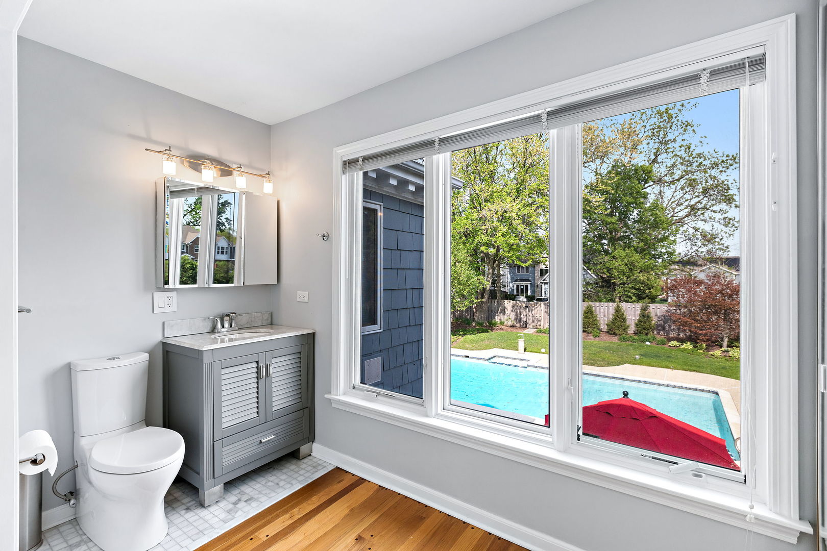 N543 Herrick Drive Wheaton, IL 60187 - Photo 15 of 29 a bathroom with a toilet sink and mirror next to a window