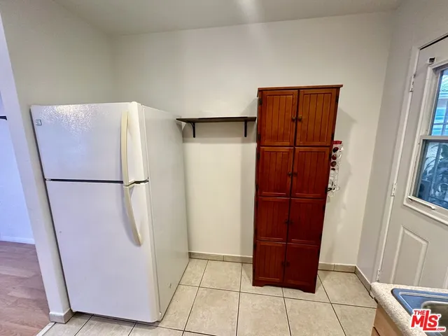 a view of storage and utility room with closet and wooden floor