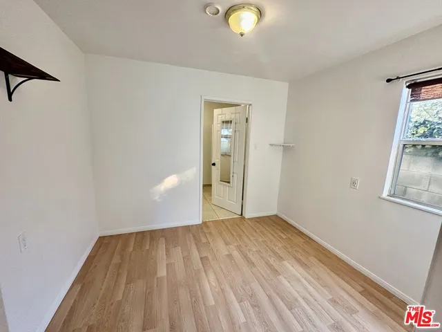 a view of a room with wooden floor and white walls
