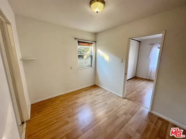 a view of an empty room with wooden floor