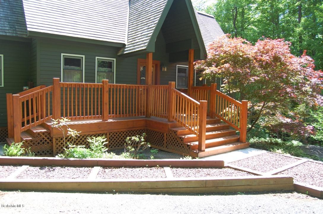 86 Leland Road Becket, MA 01223 - Photo 3 of 37 a view of a house with a small yard and wooden fence