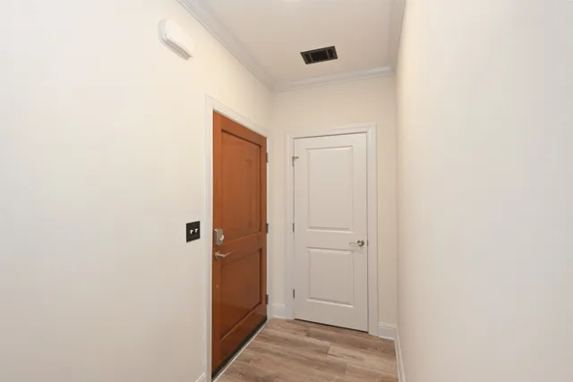 a view of a hallway with wooden floor