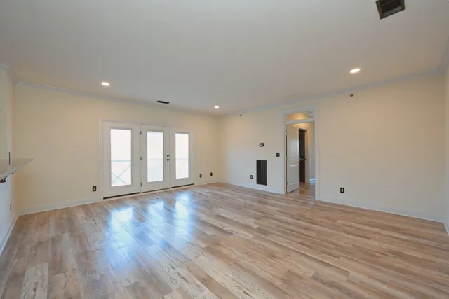a view of an empty room with wooden floor