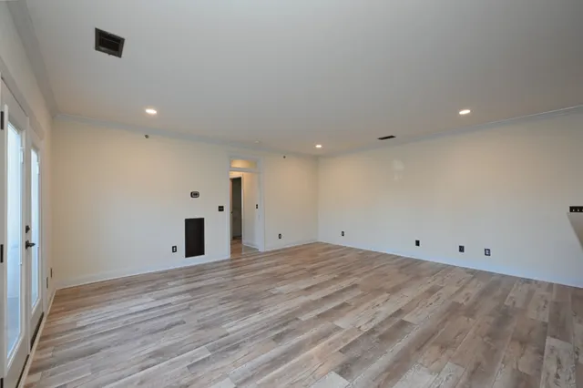 a view of empty room with wooden floor