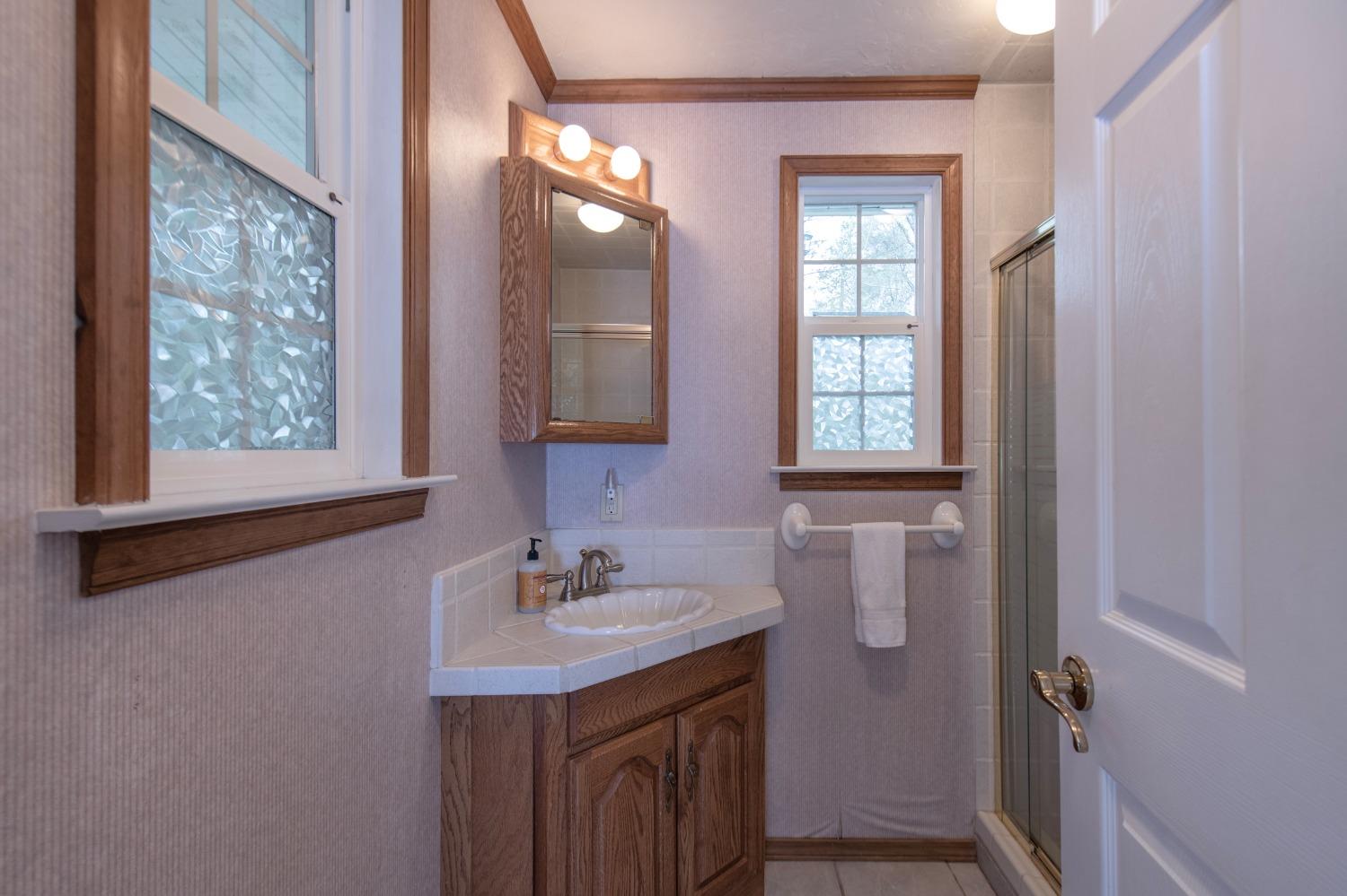 2695 Paso Pass Road Mariposa, CA 95338 - Photo 13 of 56 a bathroom with a sink a mirror and a window