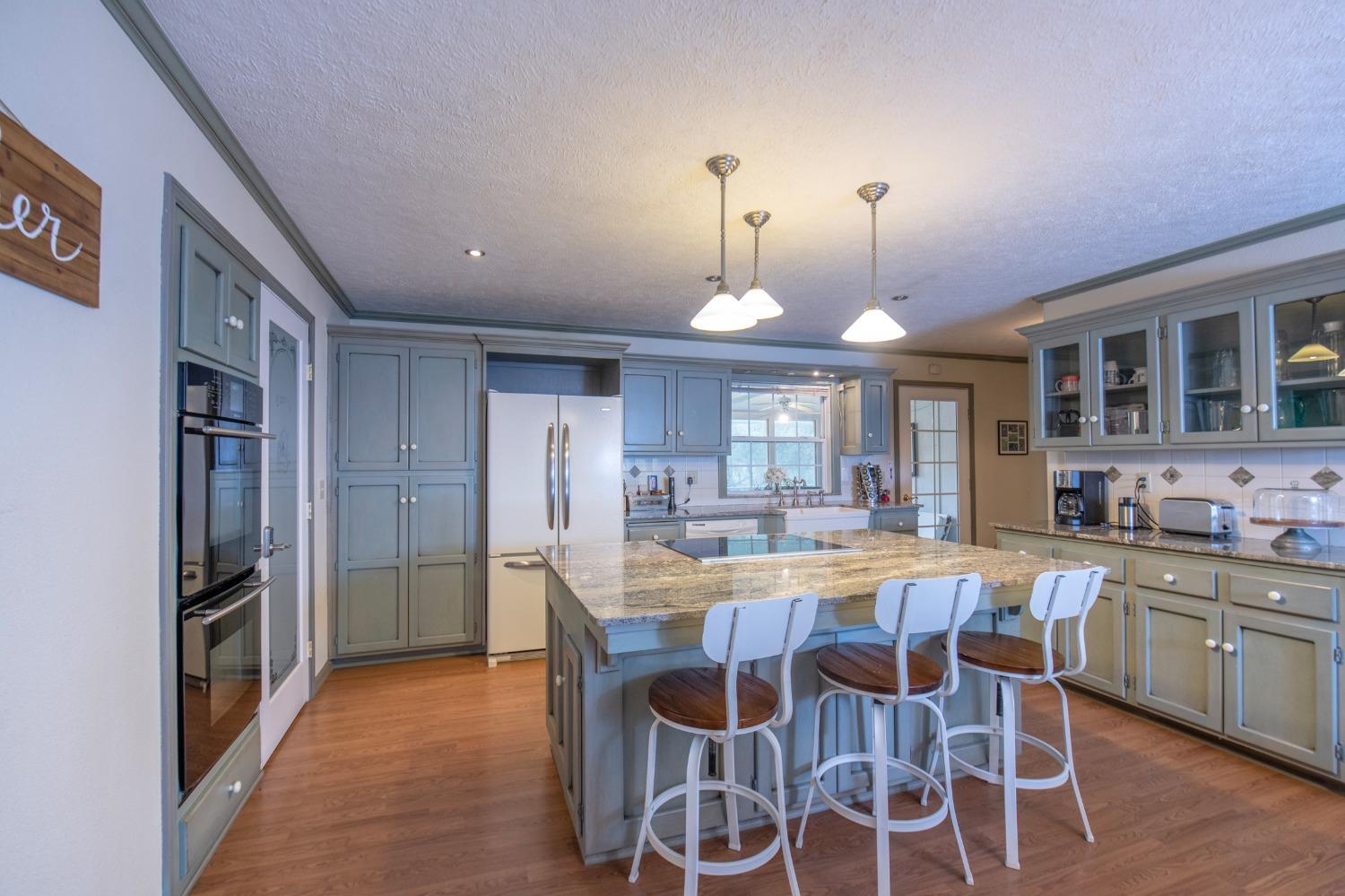 2695 Paso Pass Road Mariposa, CA 95338 - Photo 16 of 56 a dining area with stainless steel appliances kitchen island granite countertop a dining table chairs and a refrigerator