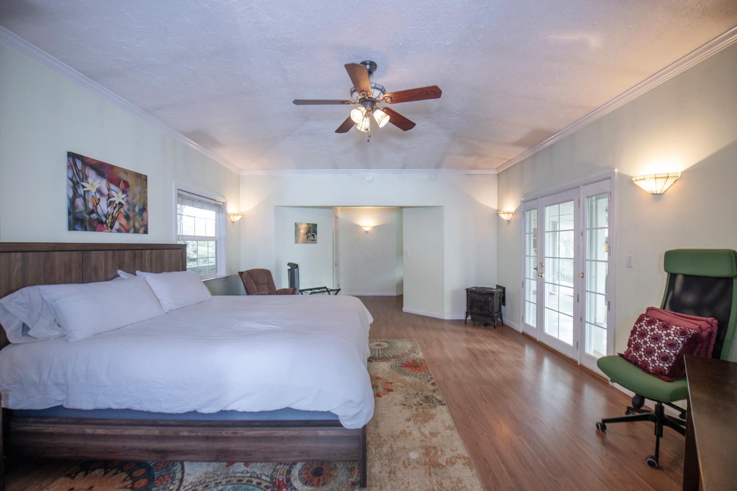 2695 Paso Pass Road Mariposa, CA 95338 - Photo 35 of 56 a spacious bedroom with a bed and a chandelier