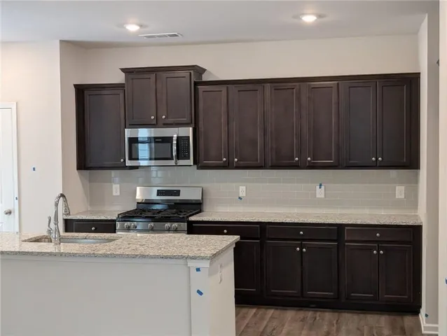a kitchen with granite countertop wood cabinets and stainless steel appliances