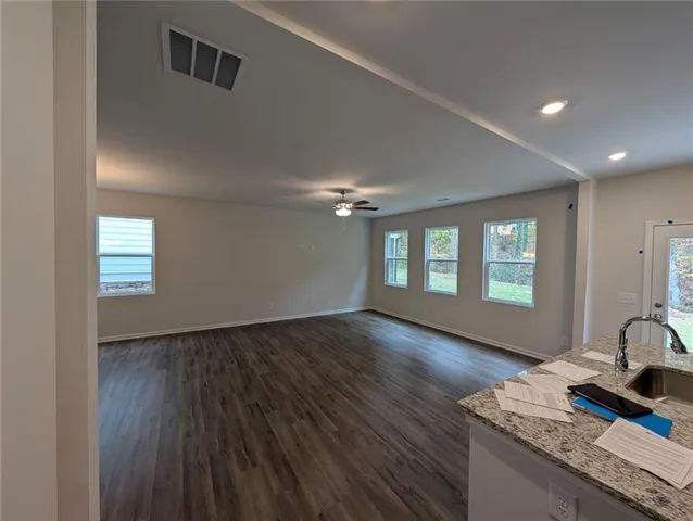 a view of an empty room with window and wooden floor