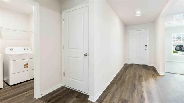 a view of a hallway with wooden floor and closet area
