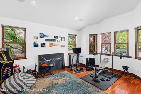 a living room with furniture a computer on desk and a large window
