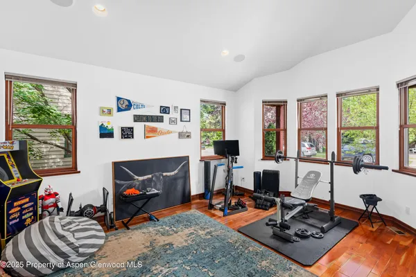 a living room with furniture a computer on desk and a large window