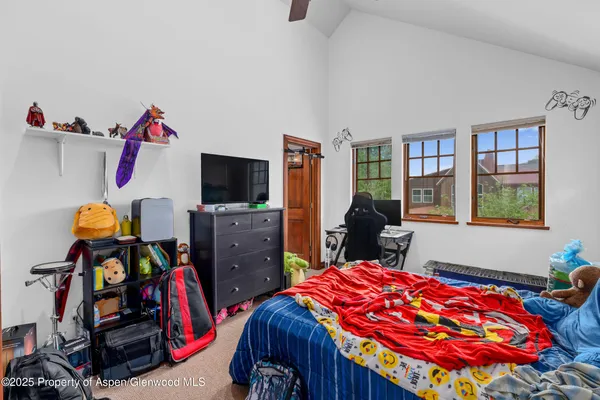 a bedroom with a bed and a flat tv screen on the dresser