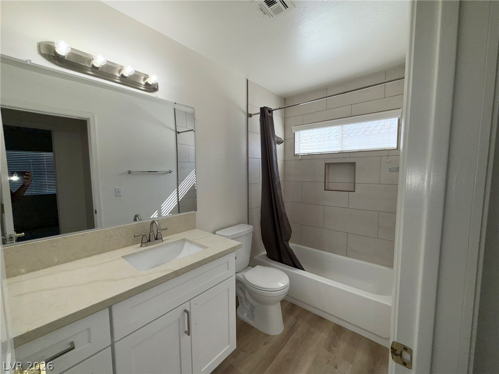 9729 Trail Rider Drive Las Vegas, NV 89117 - Photo 22 of 26 A well-appointed bath features a tiled tub-shower combination, a vanity with stone counters, and durable vinyl flooring.