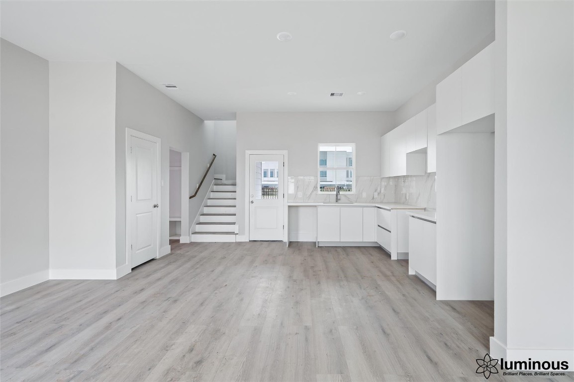 a view of a kitchen with wooden floor and stairs
