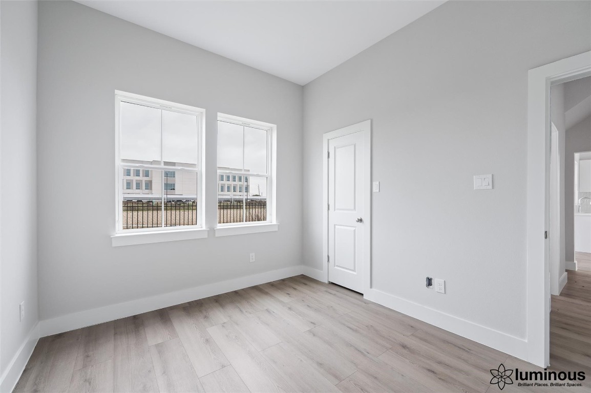 6702 Metro Boulevard, Unit 12 Houston, TX 77083 - Photo 13 of 22 a view of an empty room with wooden floor and a window