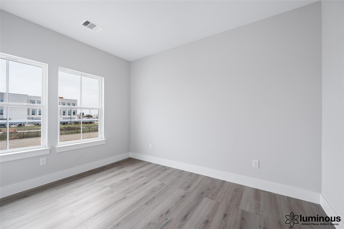 6702 Metro Boulevard, Unit 12 Houston, TX 77083 - Photo 20 of 22 an empty room with wooden floor and windows