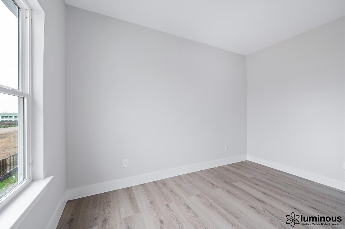6702 Metro Boulevard, Unit 12 Houston, TX 77083 - Photo 7 of 22 a view of an empty room with wooden floor and a window
