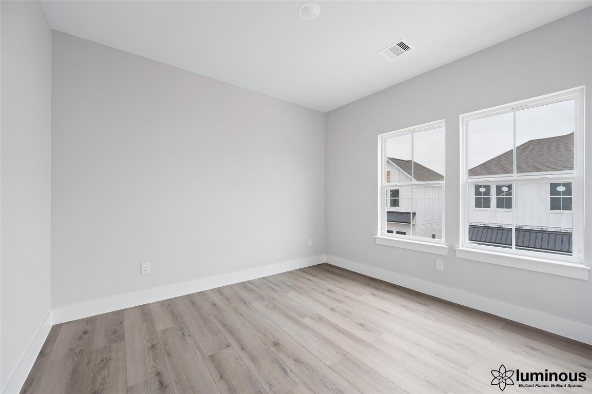6702 Metro Boulevard, Unit 12 Houston, TX 77083 - Photo 9 of 22 an empty room with wooden floor and windows