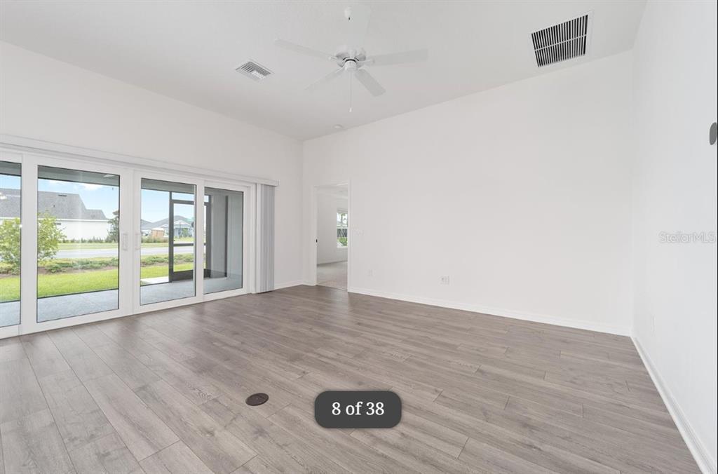 1917 Panlilio Loop The Villages, FL 34762 - Photo 4 of 11 a view of an empty room with wooden floor and a window