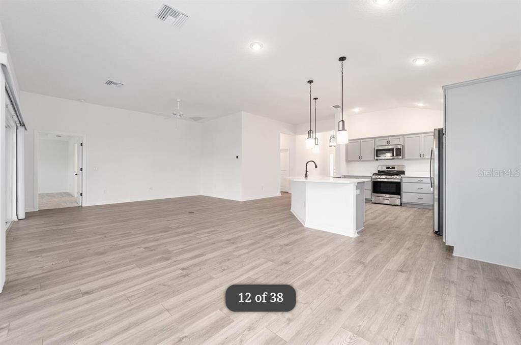 1917 Panlilio Loop The Villages, FL 34762 - Photo 5 of 11 a kitchen with kitchen island a stove a refrigerator and a sink
