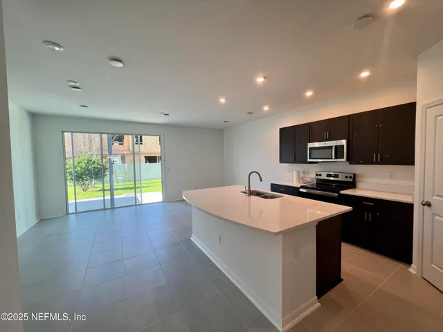 a large kitchen with stainless steel appliances lots of counter space and a sink