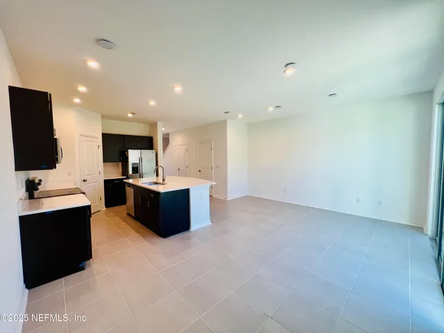 a large kitchen with stainless steel appliances a refrigerator and a microwave