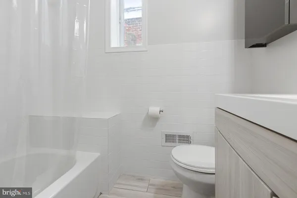 a white toilet sitting next to a bath tub