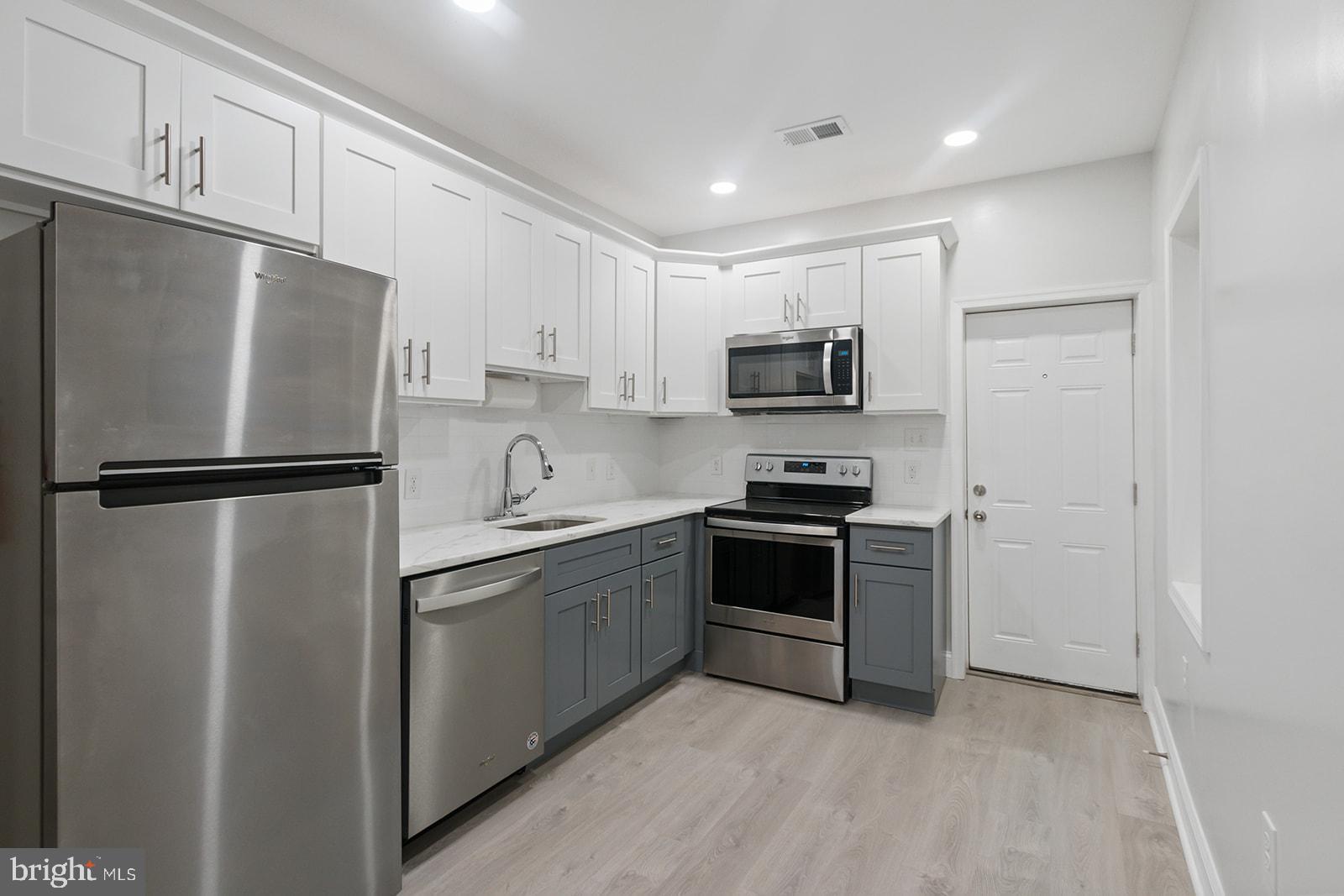5213 Rodman Street Philadelphia, PA 19143 - Photo 9 of 31 a kitchen with stainless steel appliances granite countertop a refrigerator stove a sink and dishwasher