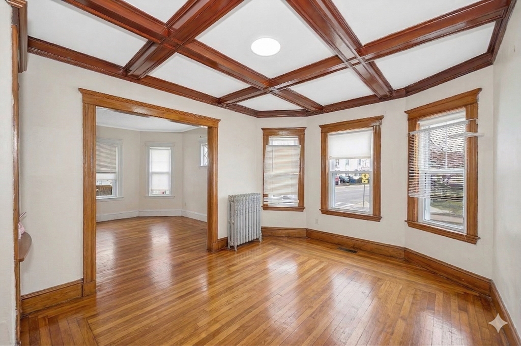 481 Lagrange Street Boston, MA 02132 - Photo 4 of 32 a view of an empty room with a window and wooden floor