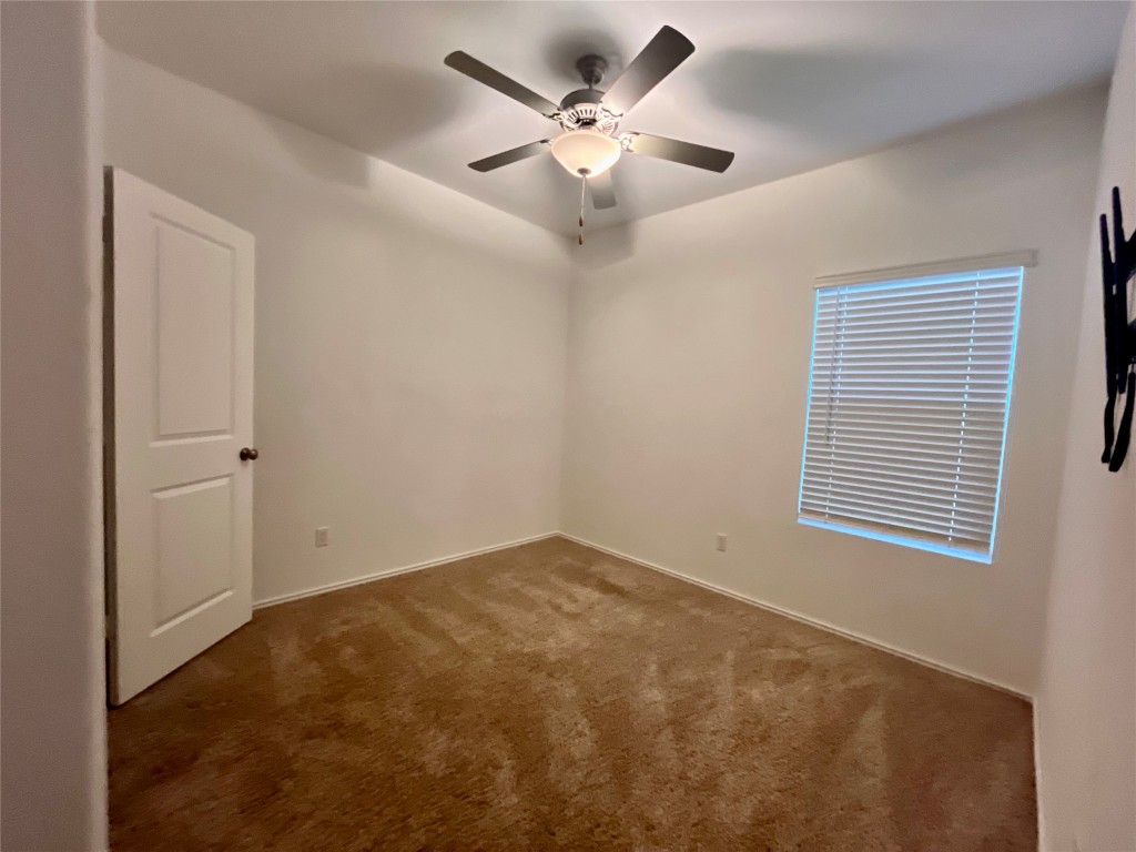 325 Geode Glen Maxwell, TX 78656 - Photo 14 of 28 en view of an empty room with a ceiling fan