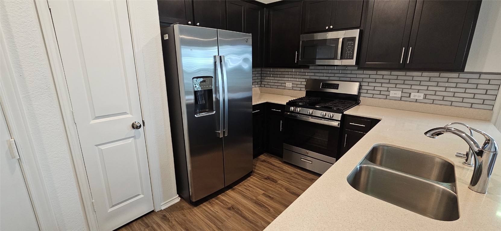 325 Geode Glen Maxwell, TX 78656 - Photo 19 of 28 a kitchen with a refrigerator sink and wooden cabinets
