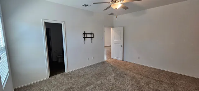 an empty room with a chandelier fan and closet