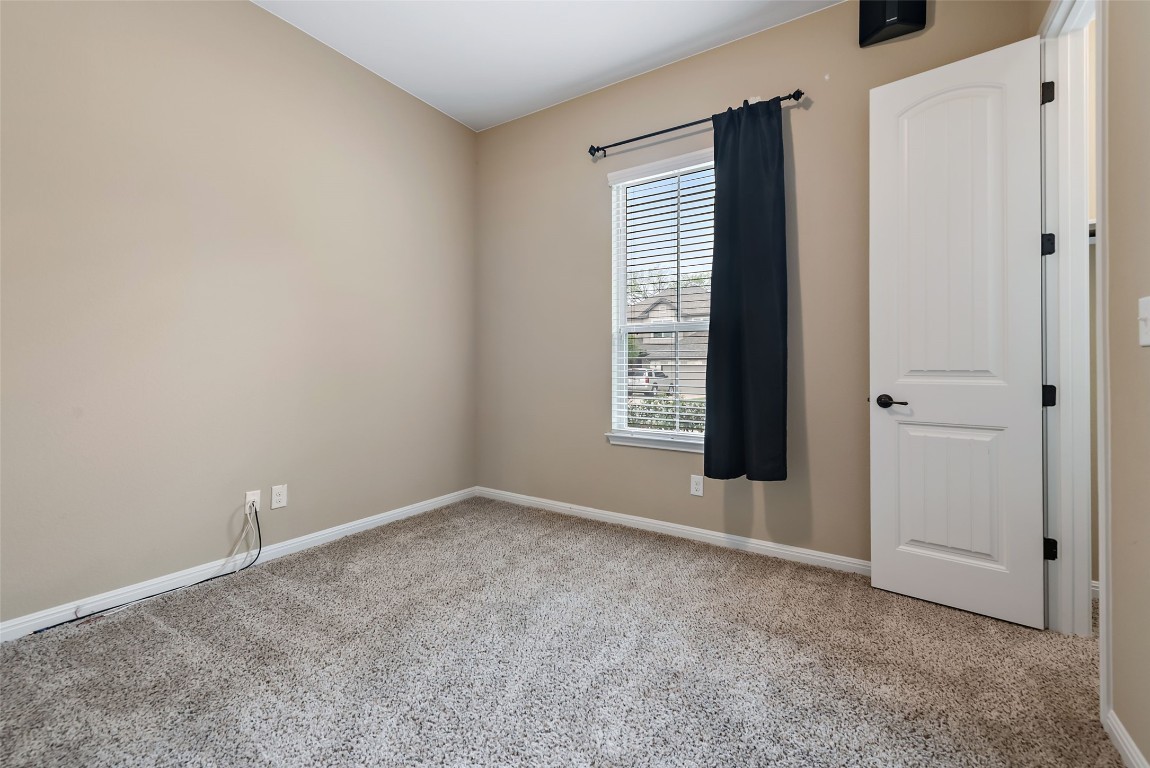 2000 Manada Trail Leander, TX 78641 - Photo 29 of 36 A well-lit bedroom features plush carpeting and a window with blinds, creating a comfortable atmosphere.