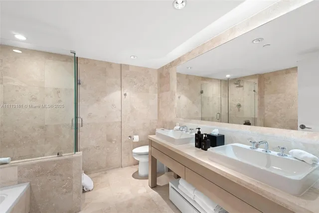 a bathroom with a double vanity sink toilet and shower