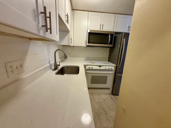 a kitchen with a sink a stove and cabinets