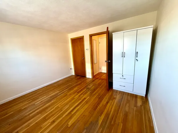 an empty room with wooden floor and sliding door