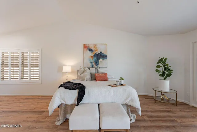 a bedroom with a bed and a potted plant