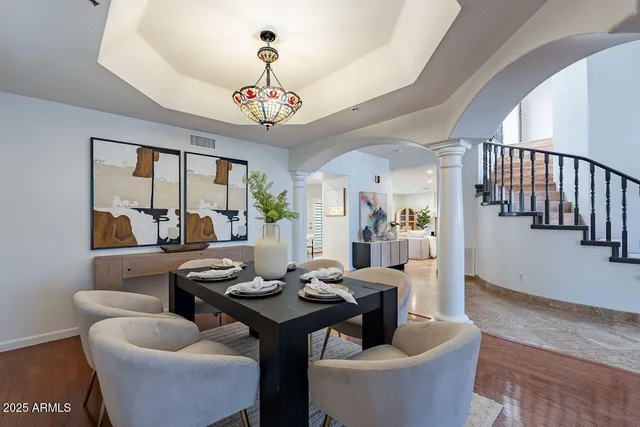 a view of a dining room with furniture a chandelier and wooden floor
