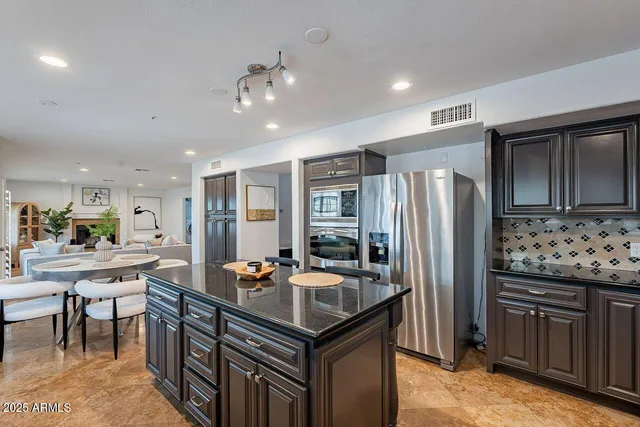 a kitchen with stainless steel appliances granite countertop a stove refrigerator and cabinets
