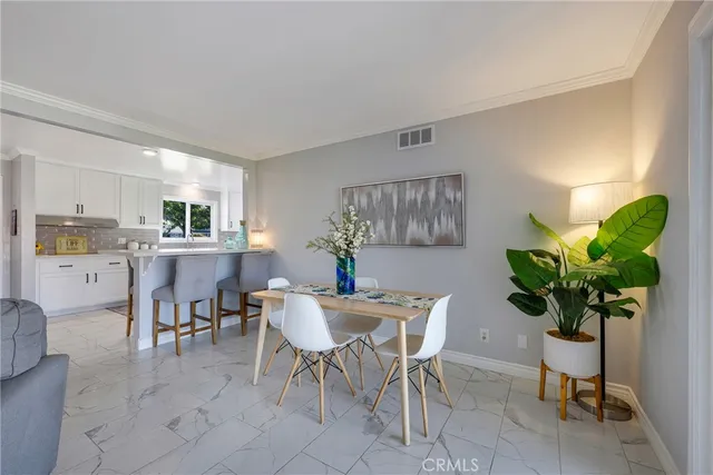 a dining room filled chandelier and kitchen view