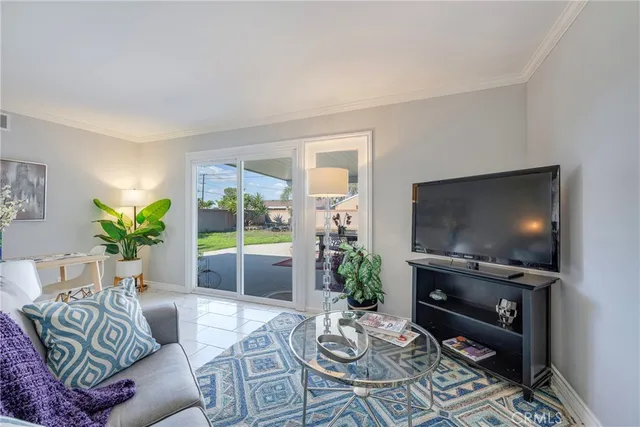 a living room with furniture a flat screen tv and a floor to ceiling window