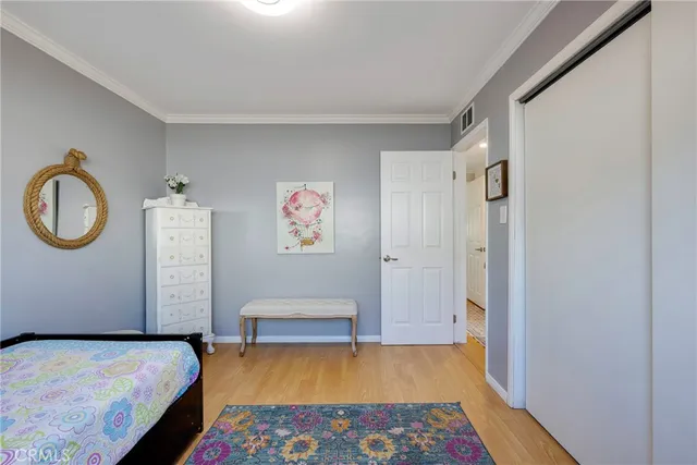 a view of a hallway with wooden floor and closet area
