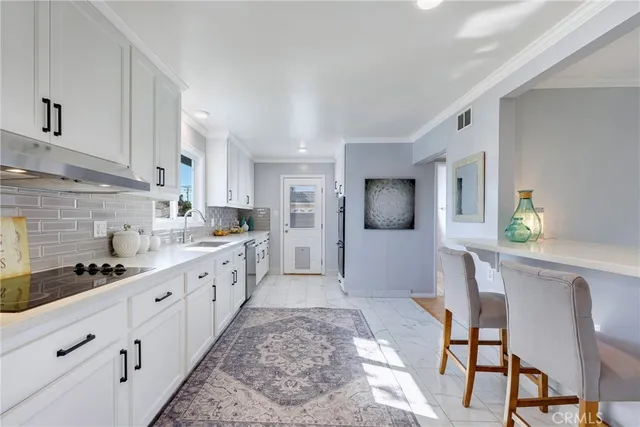 a large white kitchen with cabinets