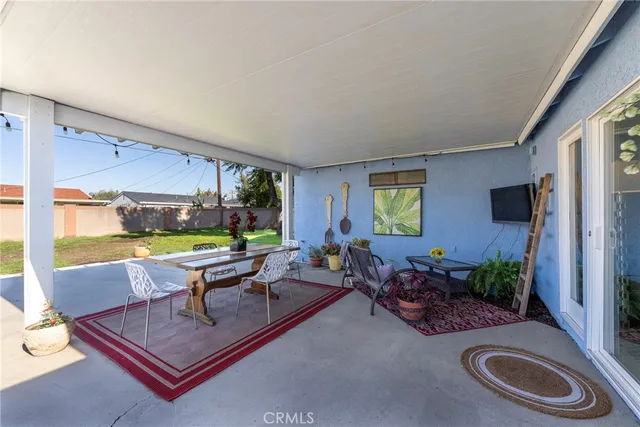 a living room with patio furniture and a potted plant