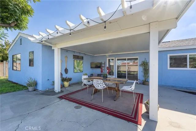 a view of a patio with couches table and chairs and potted plants
