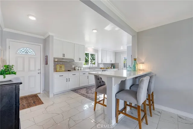 a kitchen with a dining table chairs and microwave